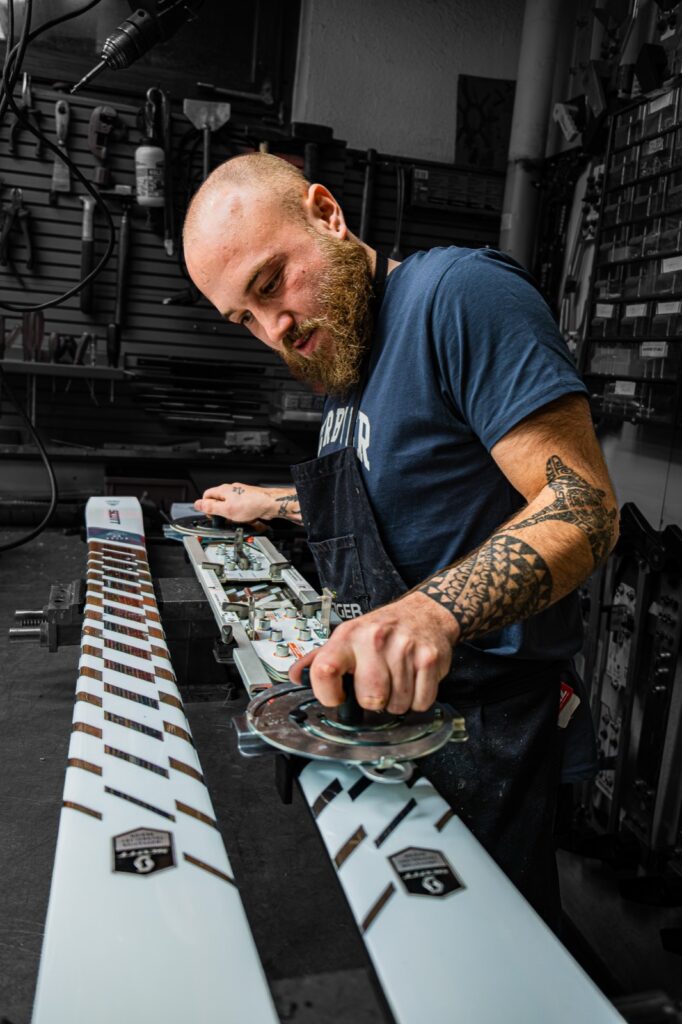 Un technicien de La Boit'askis règle les fixations d'une paire de skis à l'atelier.
