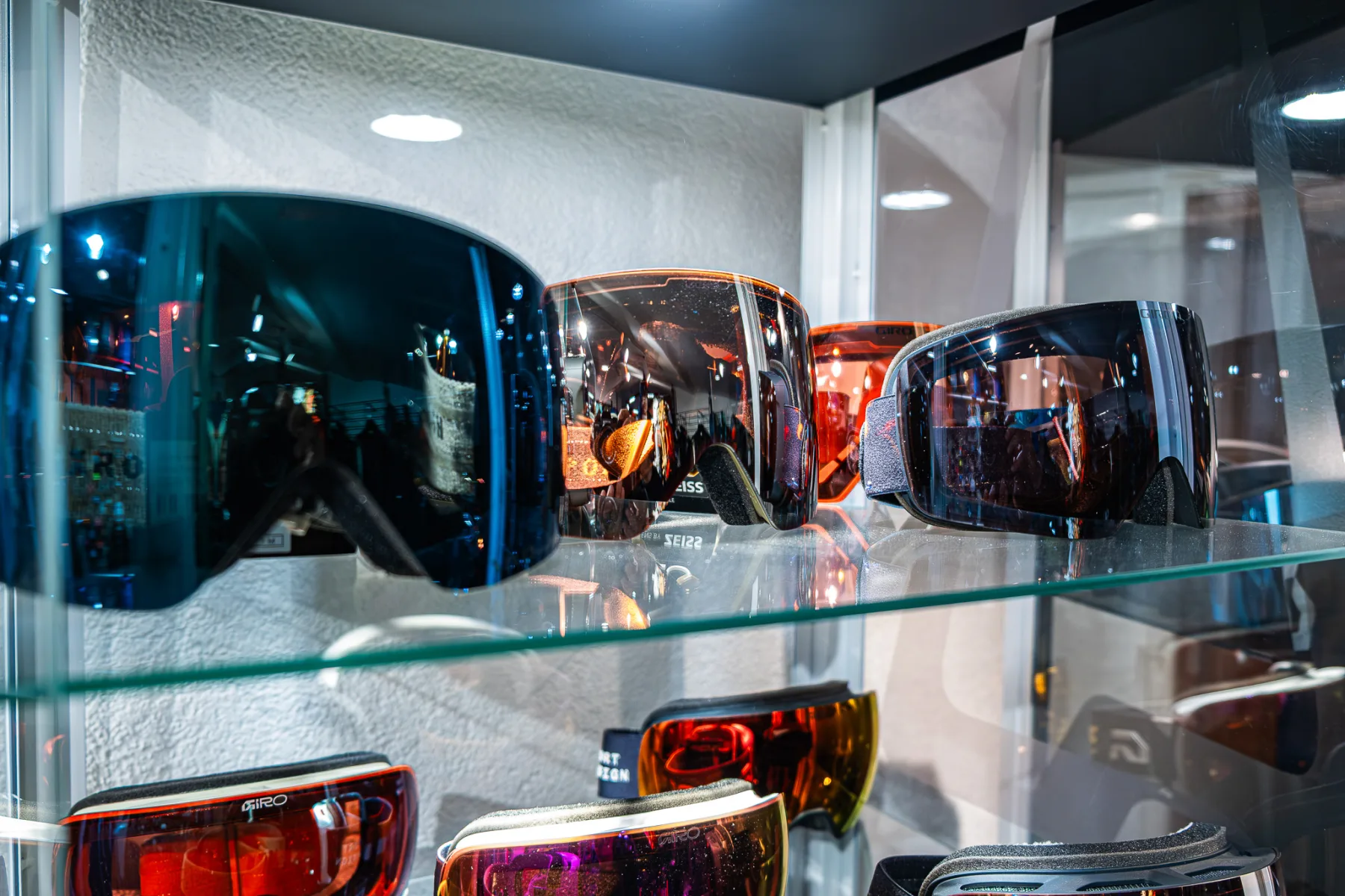Masques de ski alignés en vitrine.